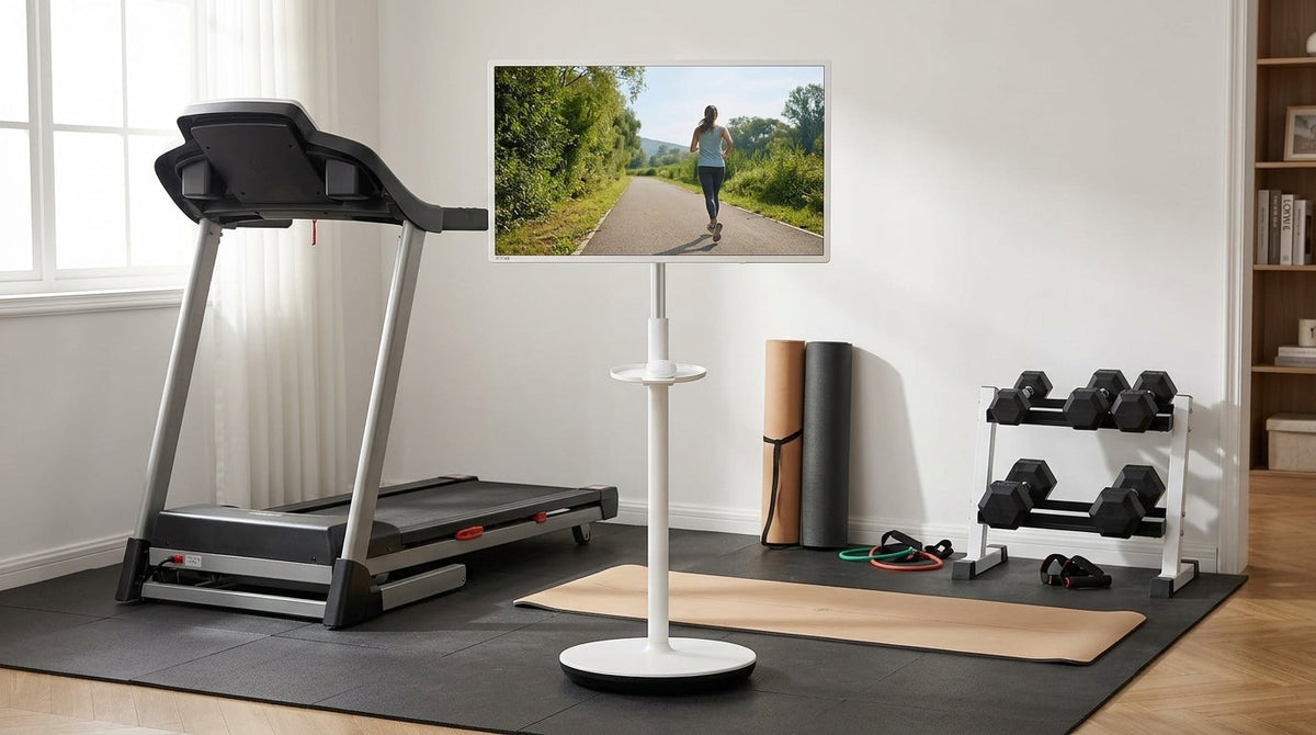 Rolling smart display in a compact home gym near a treadmill and floor workout area