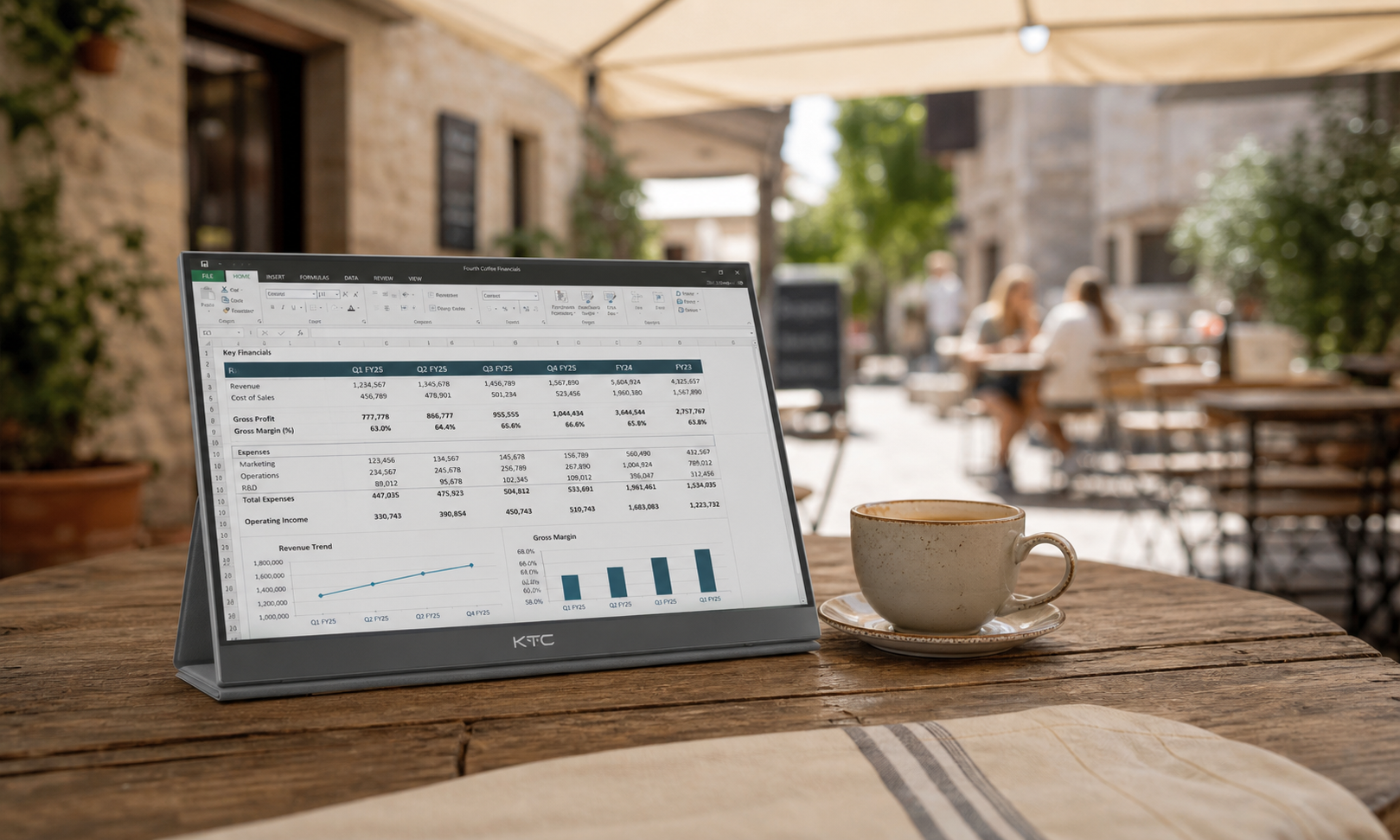Portable monitor on an outdoor cafe table with diffused sunlight filtering through an awning, screen clearly readable